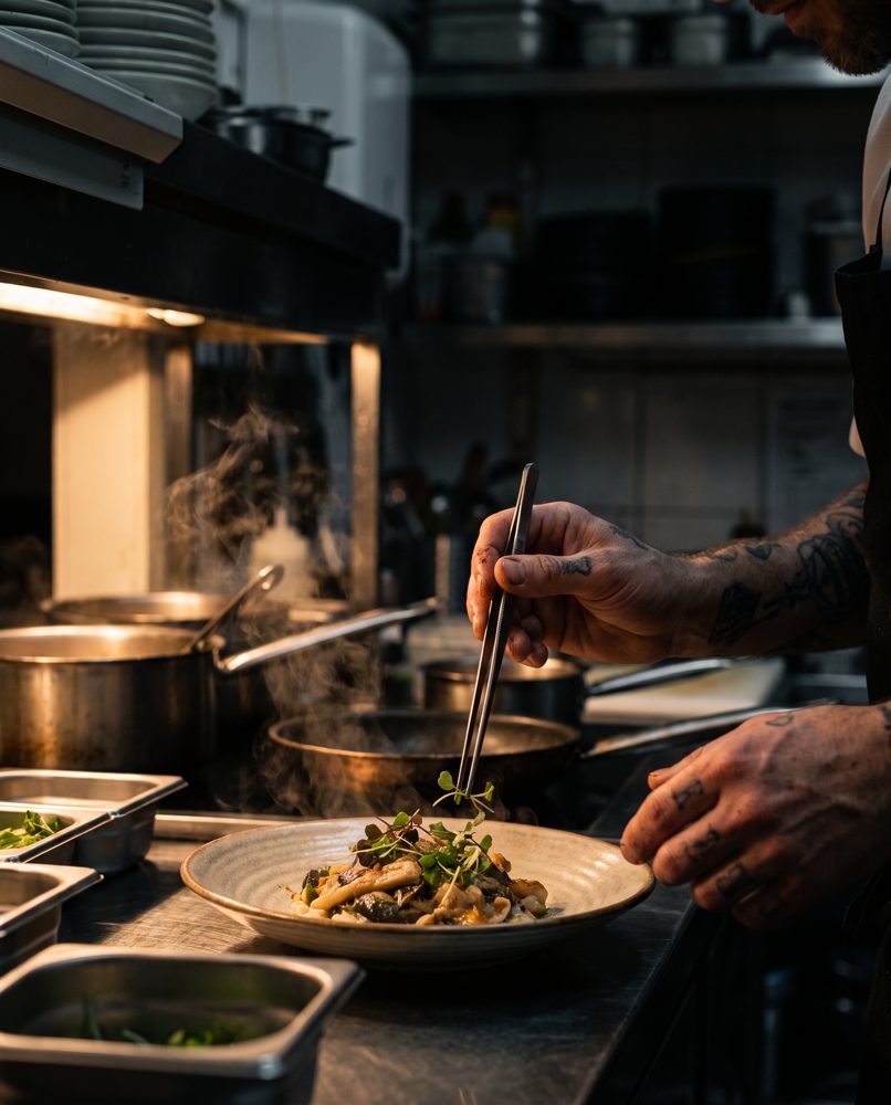 Uno chef che impiatta in cucina